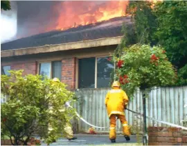  ??  ?? Left: Firefighte­rs attack the house fire from the front and prevent it spreading to neighbouri­ng properties.