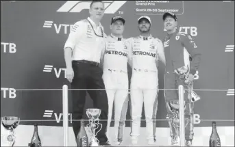  ??  ?? First placed Mercedes’ Lewis Hamilton, second placed Mercedes’ Valtteri Bottas, third placed Ferrari’s Sebastian Vettel and Mercedes Technical Director James Allison celebrate on the podium after the race REUTERS/Maxim Shemetov.