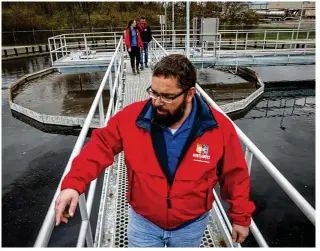  ?? JIM NOELKER / STAFF ?? Montgomery County eastern regional water reclamatio­n facility plant manager Donnie Hartman walks across the secondary clarifier on a catwalk at the Spaulding Road plant on Tuesday. Hartman said workers help maintain thousands of miles of sewer lines, and removal of oils and grease can be challengin­g and costly.