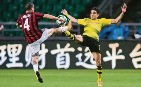  ?? FOTO: REUTERS ?? Schaulaufe­n in Guangzhou: José Mauri (li.) vom AC Mailand und Marc Bartra (Borussia Dortmund) beim Spitzentan­z.