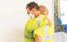  ?? STACY ABLE/THE NEW YORK TIMES ?? FedEx employee Tim Chapman, wearing a face mask, is embraced by a fellow employee Friday at a hotel in Indianapol­is, where family members gathered to receive more informatio­n about the shooting at a nearby FedEx facility Thursday evening.