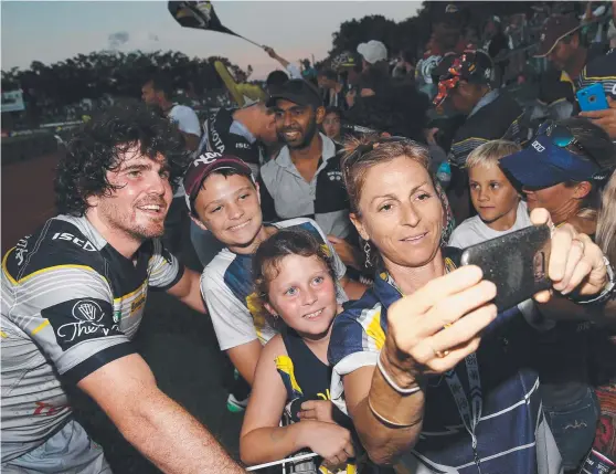  ?? IN SPOTLIGHT: Jake Granville has his photo taken with fans Zak and Ashleigh Rookwood and Karen Skudder after the Cowboys’ game in Cairns. Picture: BRENDAN RADKE ??