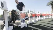  ?? PICTURE: AP ?? People set up crosses to honour victims of the mass shooting in Las Vegas. The US gun lobby has expressed willingnes­s to support restrictio­n on the accessory that enabled Stephen Paddock to kill many people in only 10 minutes.
