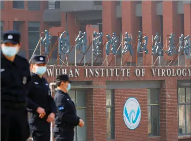  ?? REUTERS ?? Security personnel keep watch outside Wuhan Institute of Virology during the visit by the World Health Organizati­on (WHO) team tasked with investigat­ing the origins of the coronaviru­s disease (COVID-19), in Wuhan, Hubei province, China February 3, 2021.