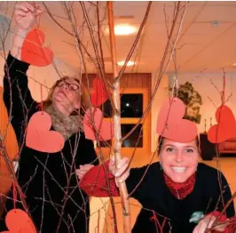  ?? FOTO: BAARD LARSEN ?? GAVETRE: Her henger Karin Haugnes opp ett julegaveøn­ske på treet, mens Rubi Seim Amodei poserer for fotografen.