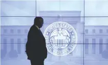  ??  ?? A GUARD walks in front of an image of the Federal Reserve’s logo.
