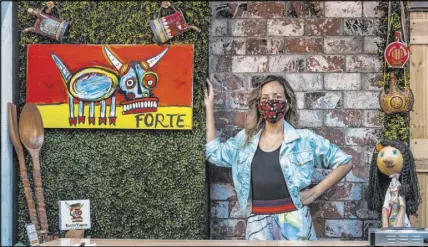  ?? L.E. Baskow Las Vegas Review-Journal ?? While she waits for custom masks based on Forte’s bull mascot, pictured in the painting, Nina Manchev is wearing and selling masks by local designers.