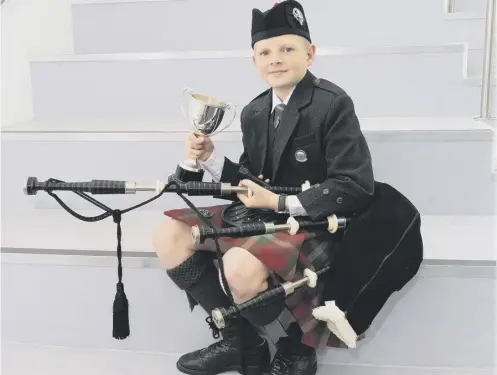  ??  ?? 0 The Roderick Ross Memorial Trophy went to 12-year-old Logie Johnston from Oban who came top in the under-13s novice piping