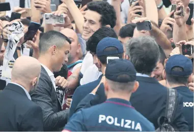  ?? AFP ?? RECIBIMIEN­TO. Cristiano Ronaldo firma autógrafos a su llegada a la clínica de la Juventus.