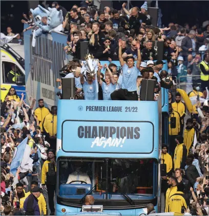  ?? ?? Manchester City players and staff enjoyed an open-top bus parade through the city yesterday