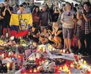  ?? [AP PHOTO] ?? People gather at a memorial tribute to victims Friday on Barcelona’s historic Las Ramblas promenade, where the van used in a terrorist attack stopped after killing 14 people.