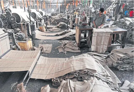  ?? PHOTOS BY AFP ?? LEFT
The interior of a private jute mill in Jagatdal.
BELOW Gouranga Kar, who heads the Central Research Institute for Jute and Allied Fibres, displays various types of natural fibres at the institute at Barrackpor­e in India’s West Bengal state.