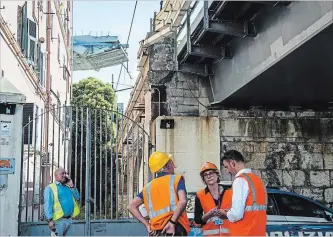  ?? NICOLA MARFISI THE ASSOCIATED PRESS ?? Workers inspect the buildings that were evacuated in the area around the collapsed Morandi highway bridge, in Genoa, northern Italy, Wednesday.