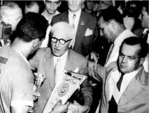  ?? AFP ?? On cloud nine: FIFA President Jules Rimet (middle) presents the World Cup to Uruguayan captain Obdulio Varela after the team beat Brazil
2-1 in the final in Rio de Janeiro.