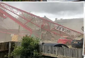  ??  ?? Crushed: A dust cloud rises moments after the crane landed on cars