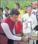  ?? HT FILE ?? ‘Rahul fan Anwar Hussain sporting the Congress president’s name, (right) Anwar giving away ‘Rahul Herbal tea’ in Gorakhpur.