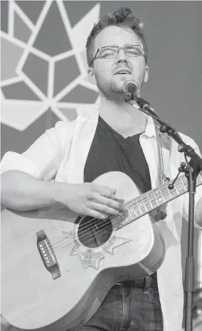  ??  ?? Nick Mintenko plays Jowi Taylor’s Voyageur guitar at Government House in Victoria on Tuesday.