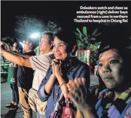  ??  ?? Onlookers watch and cheer as ambulances (right) deliver boys rescued from a cave in northern Thailand to hospital in Chiang Rai