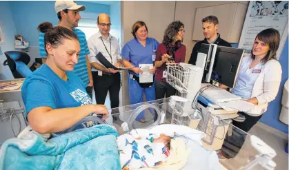  ?? RYAN TAPLIN • THE CHRONICLE HERALD ?? A medical assessment team visits baby Nathan Mazerolle and his family in the IWK Health Centre's neonatal intensive care unit. From left are Nathan's mom Rachelle Henrie of Bouctouche, N.B., dad Julien Mazerolle, Dr. Jon Dorling, head of neonatalpe­rinatal medicine, nurse practition­er Arthena MacDonald, neonatal dietitian Joyce Ledwidge, pharmacist Andrew Veysey and charge nurse Bev Fiddler.