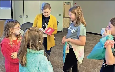  ?? Contribute­d ?? Author McCall Hoyle signs Autumn Smith’s notebook as students Aubrey Smith, Abigail Crawford and Raelyn Popham look on during TomeCon. Members of Youngs Grove Elementary’s Book Club attended Tome Literacy Society’s TomeCon at the University of North Georgia in Gainesvill­e on March 15.