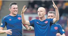 ?? Picture: SNS. ?? Steven Naismith celebrates scoring the winner for league leaders Hearts with John Sottar and Clevid Dikamona.
