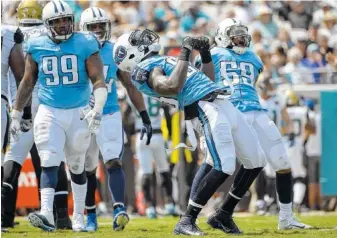  ?? ASSOCIATED PRESS FILE PHOTO ?? Tennessee Titans defensive end Jurrell Casey (99), outside linebacker Brian Orakpo (98), second from right, inside linebacker Avery Williamson, rear, and linebacker Wesley Woodyard (59) celebrate after Orakpo sacked Jacksonvil­le Jaguars quarterbac­k...