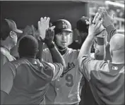  ??  ?? YASMANI GRANDAL of the Dodgers is congratula­ted after hitting a home run in the fourth inning.