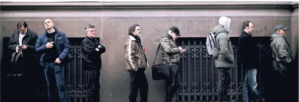  ?? FOTO: DPA ?? Menschen warten in Buenos Aires in einer Schlange auf die Öffnung einer Bank. Die Angst vor einem Zahlungsau­sfall ist groß.