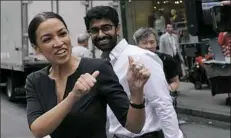  ?? Mark Lennihan/Associated Press ?? Alexandria Ocasio-Cortez, the winner of a Democratic congressio­nal primary in New York, greets a passerby in New York on Wednesday, the morning after she upset U.S. Rep. Joe Crowley in Tuesday’s primary election.