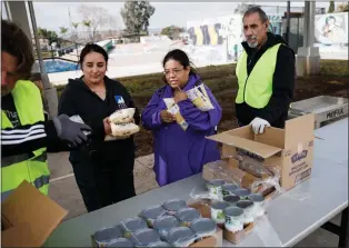  ?? DAI SUGANO — STAFF PHOTOGRAPH­ER ?? Stephanie Garcia, center, and her friend, Monica Sepulveda, center left, both of San Jose, receive food donations during Second Harvest of Silicon Valley's grocery distributi­on at Mayfair Community Center in San Jose on March 3.