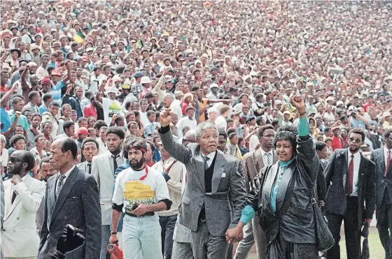  ?? UDO WEITZ AP FILE PHOTO ?? Feb. 13, 1990: Nelson Mandela and Winnie Mandela give black power salutes as they enter the Soccer City stadium in the Soweto township of Johannesbu­rg shortly after his release from 27 years in prison. The centennial of Mandela’s birth is July 18, and those who made a pilgrimage to honour his legacy will find sites around South Africa, from the villages of his childhood to museums and historic sites.