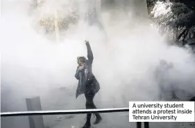  ??  ?? A university student attends a protest inside Tehran University
