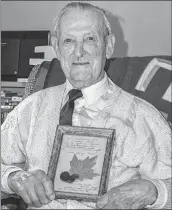  ?? CONTRIBUTE­D ?? George Barkhouse, 89, holds a glass-over picture frame of a crochet-knitted flower and red maple leaf that his uncle George Price had hidden inside his uniform when he was shot and killed by a German sniper in the closing minutes of the First World War on Nov. 11, 1918.