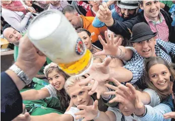  ?? FOTO: DPA ?? Besucher freuen sich beim Auftakt zum Oktoberfes­t 2017 über ihr erstes Bier. Für Millionen Besucher ist das Oktoberfes­t eine große Gaudi, für Brauer, Wirte, Einzelhänd­ler und Hotels ist es ein großes Geschäft.