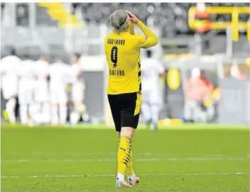  ?? FOTO: MEISSNER/POOL AP/DPA ?? Erling Haaland schlägt sich nach der 1:2-Heimnieder­lage gegen Eintracht Frankfurt die Hände vors Gesicht. Borussia Dortmund wird die Qualifikat­ion für die Champions League wohl verpassen.