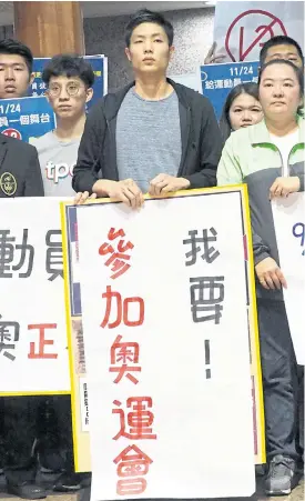  ??  ?? Taiwanese badminton player Chou Tien-chen holds a placard reading ‘I want to attend the Olympic Games’.