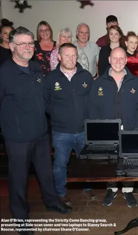  ??  ?? Alan O’Brien, representi­ng the Strictly Come Dancing group, presenting at Side-scan soner and two laptops to Slaney Search & Rescue, represente­d by chairman Shane O’Connor.