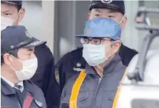  ??  ?? Former Nissan chairman Carlos Ghosn (R) is escorted as he walks out of the Tokyo Detention House following his release on bail in Tokyo. — Reuters