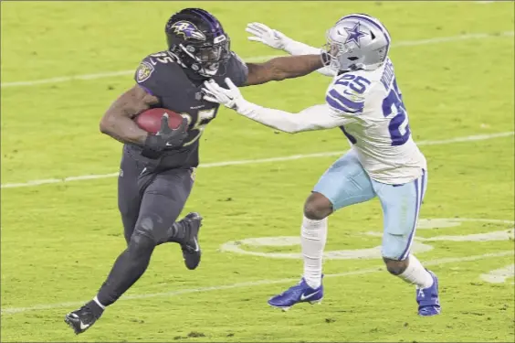  ?? Rob Carr / Getty Images ?? Running back Gus Edwards of the Baltimore Ravens rushes past free safety Woods of the Dallas Cowboys during the fourth quarter of Monday night’s game at M&T Bank Stadium in Baltimore. The Ravens’ relentless rushing attack amassed 294 yards.