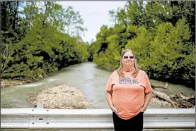  ?? Arkansas Democrat-Gazette/MITCHELL PE MASILUN ?? Sharon Pierce of Mount Judea stands over Big Creek near its confluence with the Buffalo River. Pierce, who taught the owners of C&H Hog Farms in school, said she supports the operation but would be against another farm of that size moving into the area.