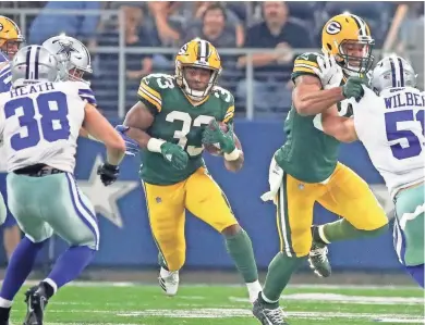  ?? JIM MATTHEWS / USATODAY NETWORK-WISCONSIN ?? Green Bay Packers running back Aaron Jones bursts through a hole Sunday against the Dallas Cowboys as tight end Lance Kendricks blocks.