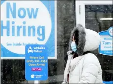  ?? THE ASSOCIATED PRESS ?? A woman walks past a “Now Hiring” sign displayed at a CD One Price Cleaners on Feb. 6, in Schaumburg, Ill.