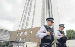  ?? Picture: AP. ?? Police officers outside the Dorney tower on the Chalcots Estate, in north London, where residents are unhappy about having to leave over potential fire risks.