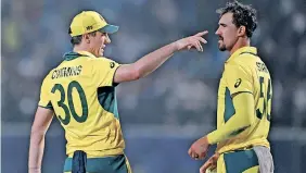  ?? ?? AUSTRALIA’S captain Pat Cummins (L) speaks with Mitchell Starc as if warning his teammate of the danger England pose as they face off in the 2023 ICC Men’s Cricket World Cup in a battle for semi-final spots. | AFP