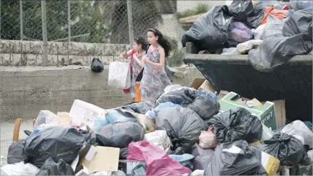  ?? Majdi Mohammed Associated Press ?? A DUMPSTER overf lows in Kafr Aqab. Garbage collectors contracted by the Jerusalem city government pick up trash at their whim.