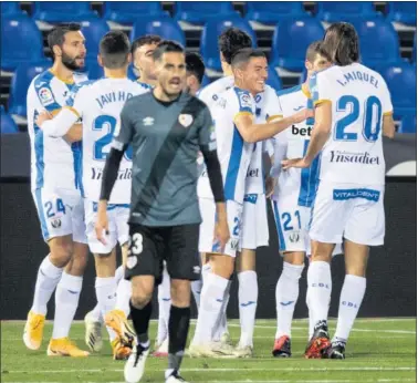  ??  ?? Óscar Valentín, del Rayo, anima a sus compañeros, mientras los jugadores del Leganés celebran el gol.