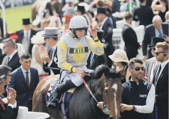  ??  ?? Jockey Ryan Moore celebrates winning the Investec Diomed Stakes with Zaaki during Derby Day of the 2019 Investec Derby Festival at Epsom Racecourse.