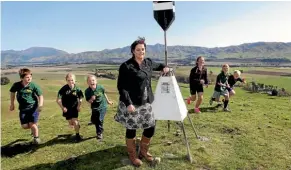  ?? PHOTO:SCOTT HAMMOND/STUFF ?? Seddon School principal and chairperso­n of the Marlboroug­h Principal’s Associatio­n and Seddon School principal Tania Pringle, with students at the trig station on Star Hill ahead of the school’s famed Tussock Run.