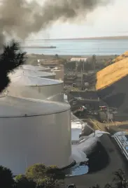  ?? Sarahbeth Maney / Special to The Chronicle ?? Fire crews work to extinguish flames after a blast at the NuStar Energy facility in Crockett on Tuesday.