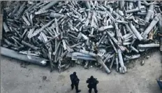  ?? Associated Press ?? Police officers on Saturday look at collected fragments of Russian rockets in Kharkiv, Ukraine.